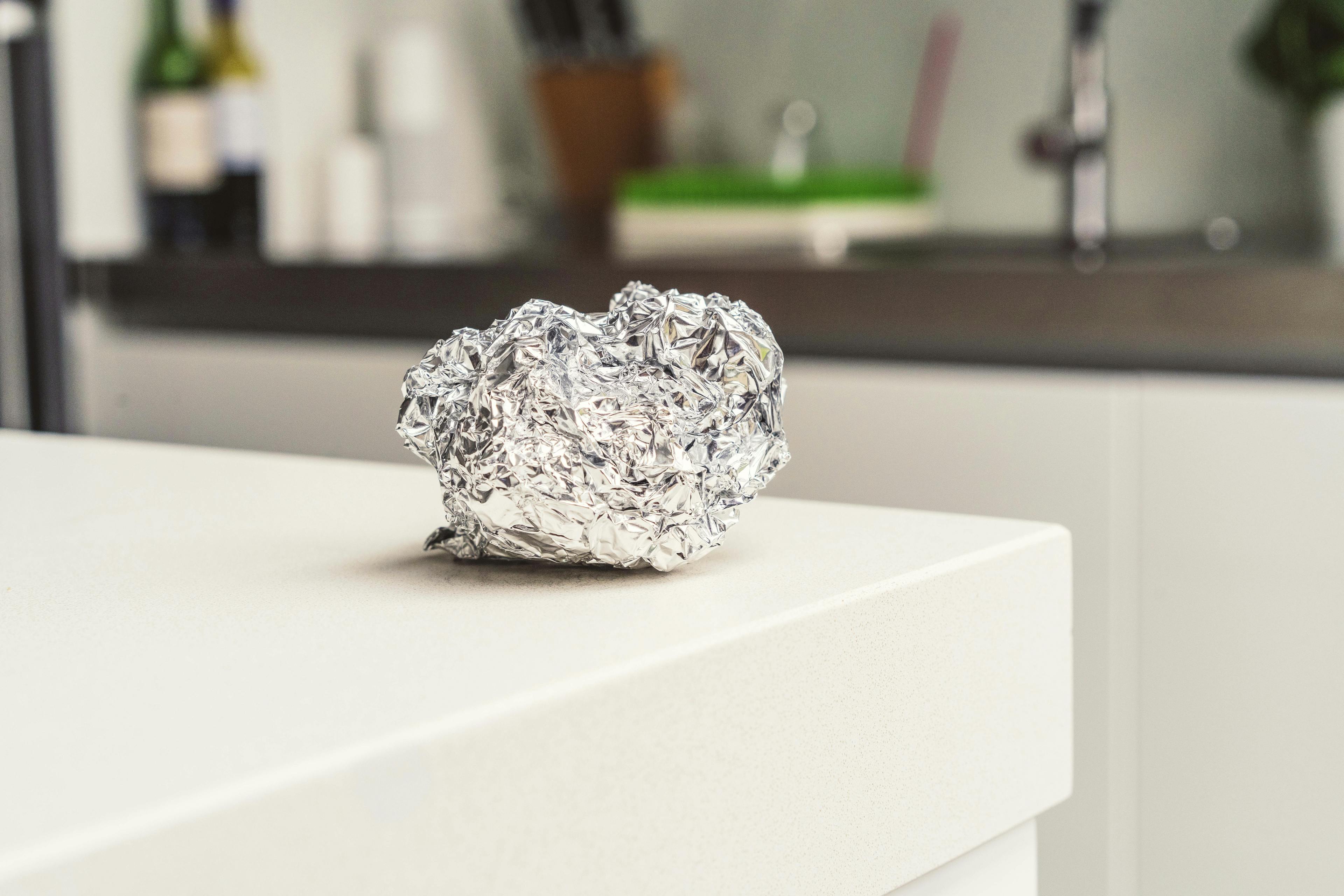 Scrunched-up ball of foil on a white kitchen counter