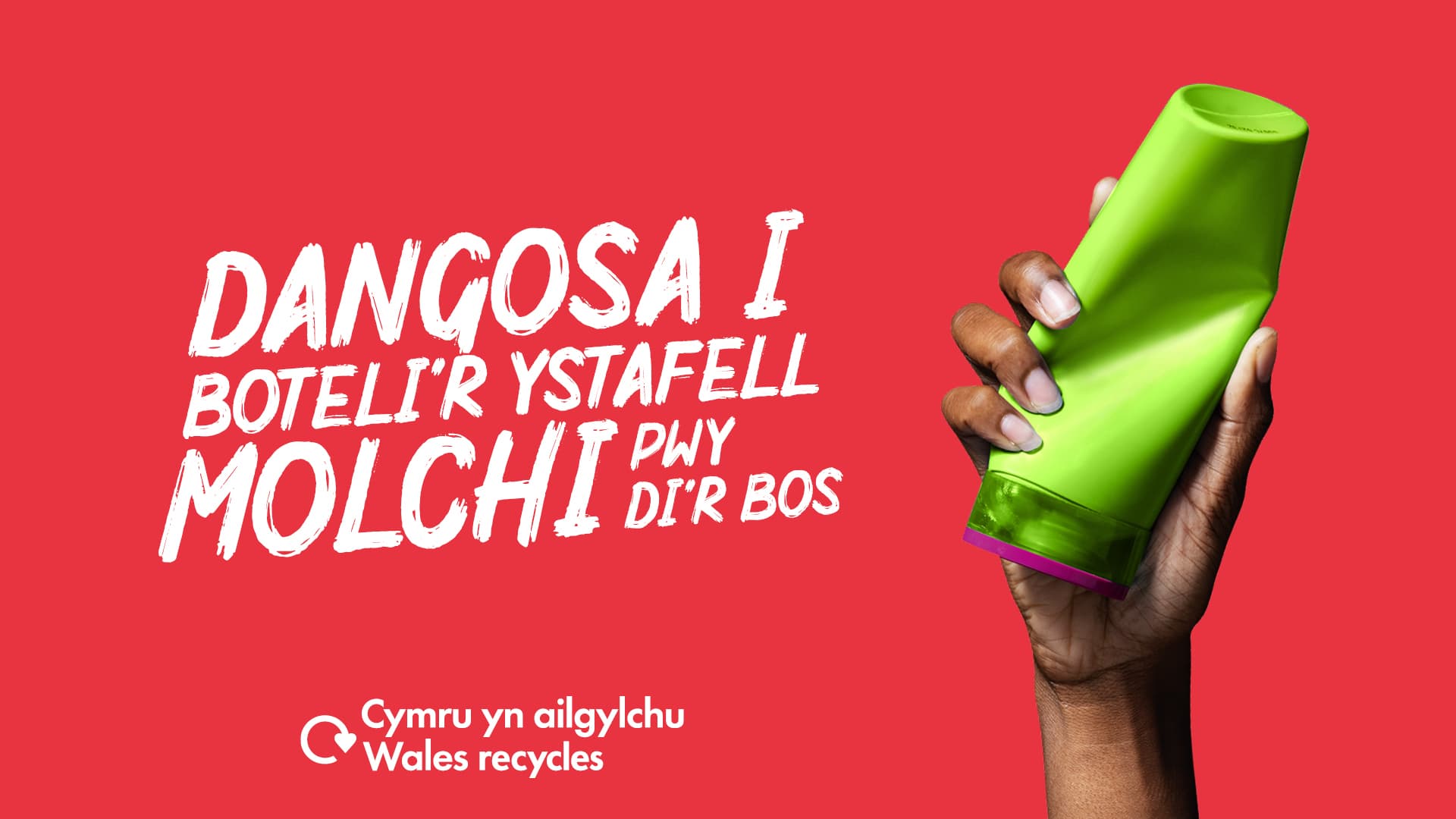 Llaw dynes yn dal potel plastig gwyrdd gyda'r geiriau "Dangosa i boteli'r ystafell molchi pwy di'r bos"