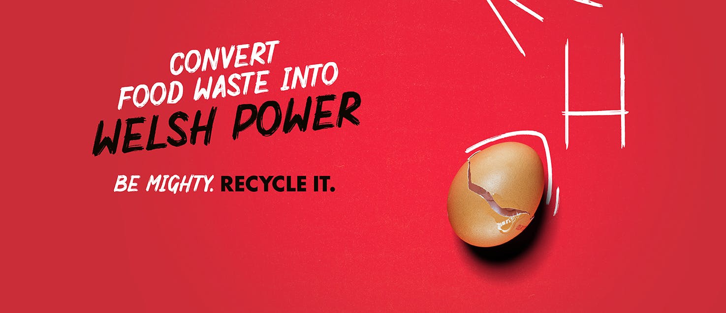 A cracked egg shell with some chalk drawn rugby posts and trees on a red background with the slogan "Convert food waste into Welsh power.