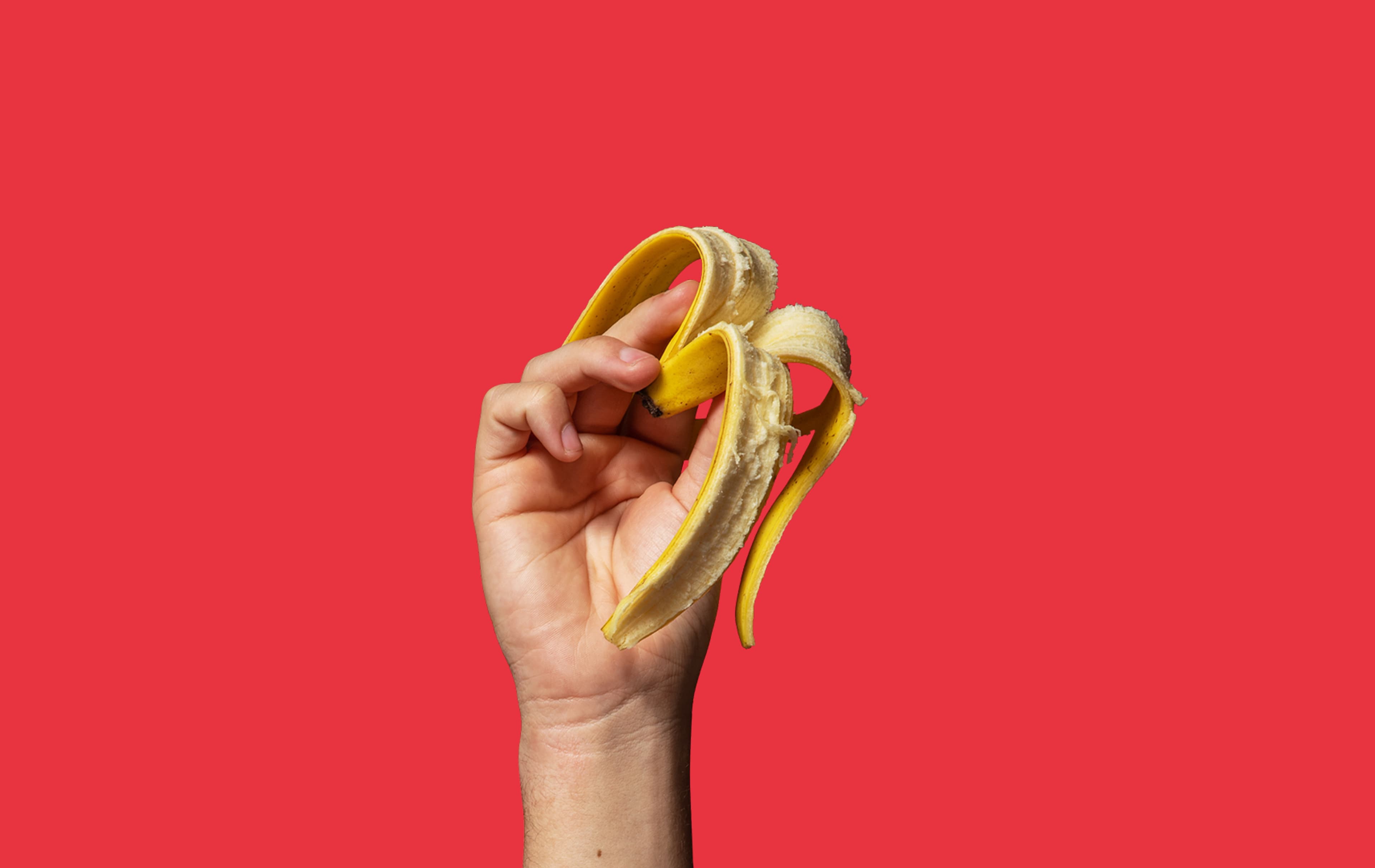 Llaw yn dal croen banana