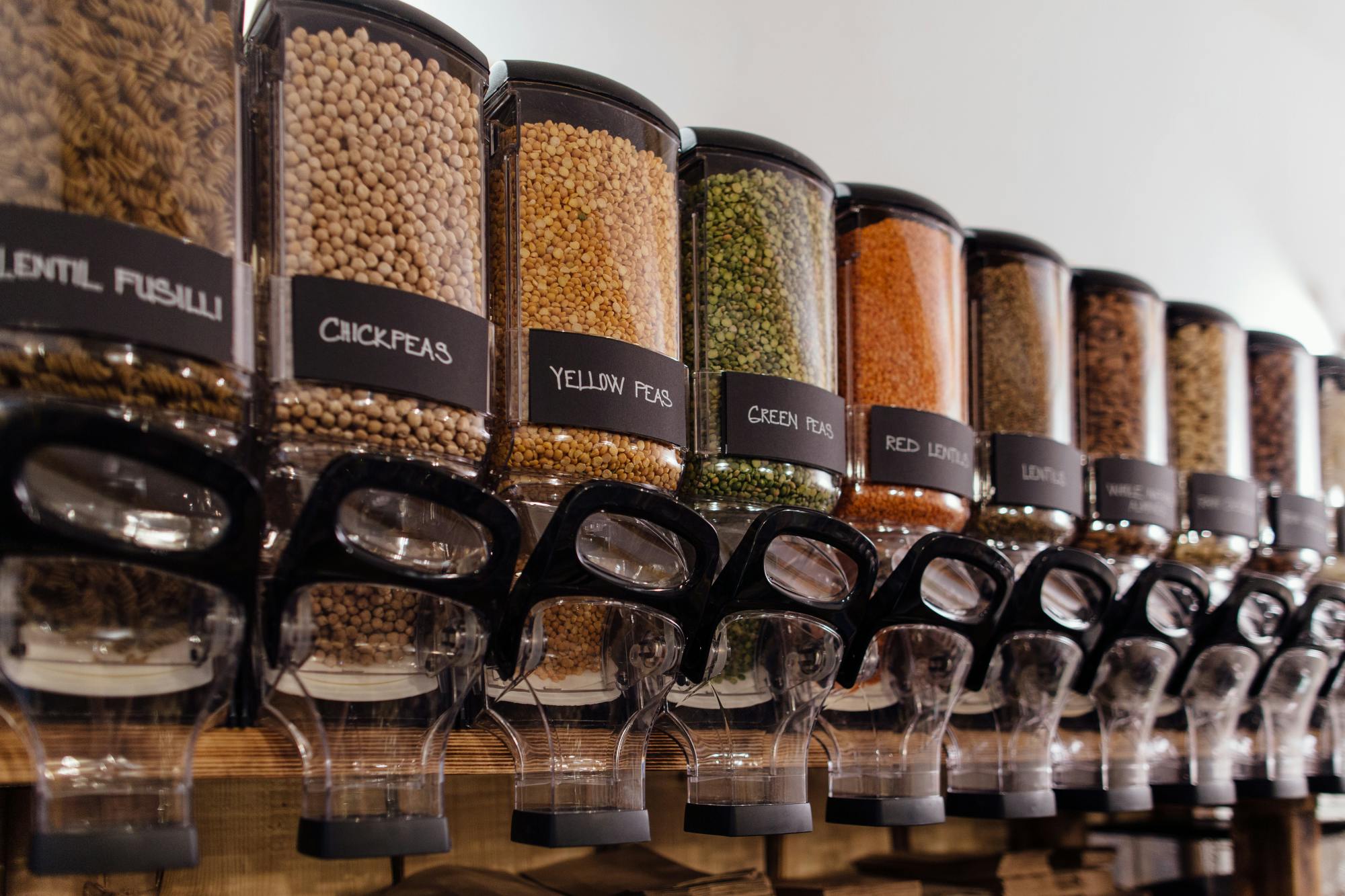 Row of clear dispensors containing cereals and grains